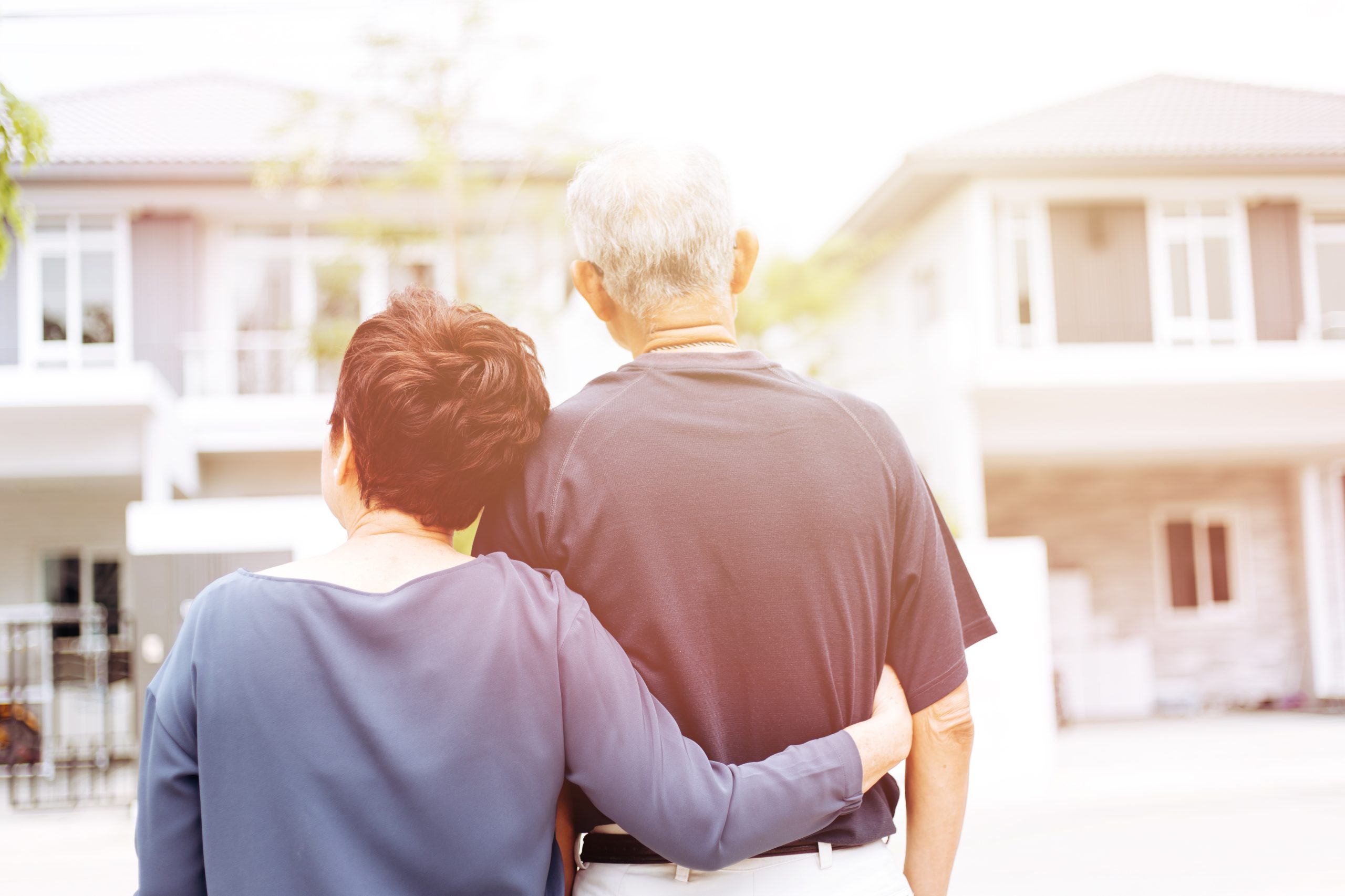 Old couple in front of house after home equity refinance