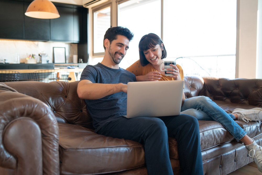 couple buying home for less than 20% down sitting on couch together